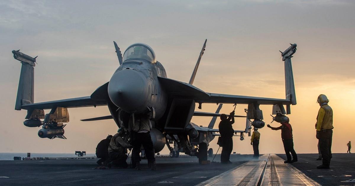 Sailors aboard the aircraft carrier Dwight D. Eisenhower secure an F/A-18E Super Hornet attached to the 
