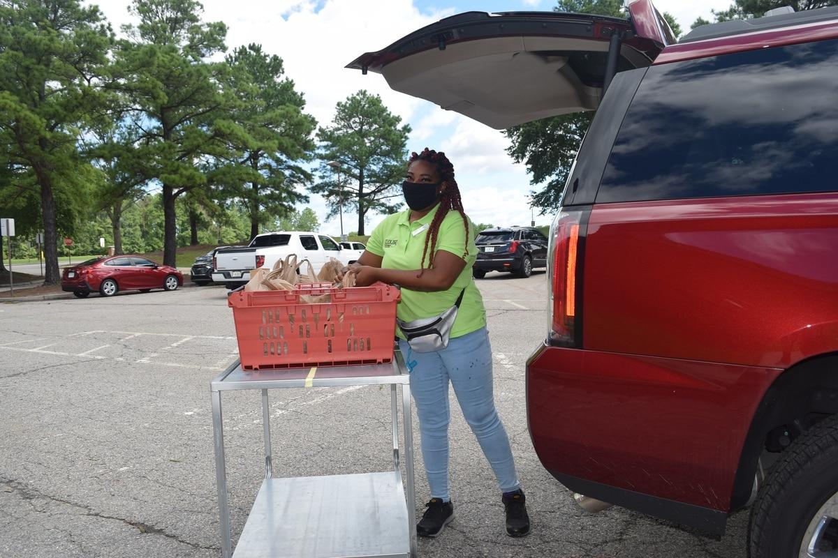 Tiara Edwards loads groceries in the vehicle of a customer who has ordered items online from the commissary at Fort Lee, Va. (Rick Brink/Defense Commissary Agency) More than half of stateside commissaries will have curbside pickup within a month