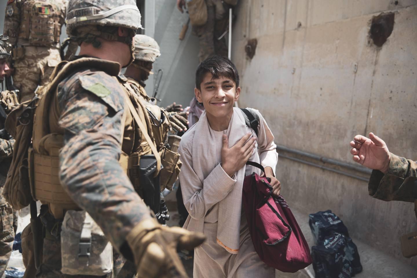 A boy is processed through an evacuee control checkpoint during an evacuation at Hamid Karzai International Airport, Kabul, Afghanistan, Aug. 18. (Staff Sgt. Victor Mancilla/Marine Corps) (U.S. Central Command Public Affa) Marines in Afghanistan pull baby over barbed wire to safety