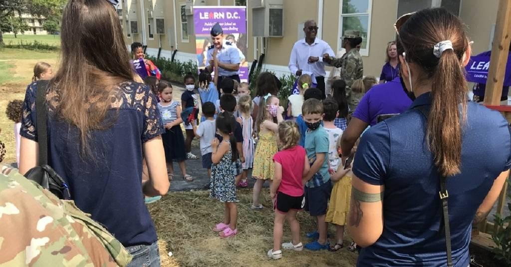 Children converge as Air Force Col. Mike Zuhlsdorf, commander of Joint Base Anacostia-Bolling and others cut the ceremonial ribbon on the new charter school Aug. 26. (Karen Jowers/Staff) JBAB charter school opens after years of persistence by military and civilian parents