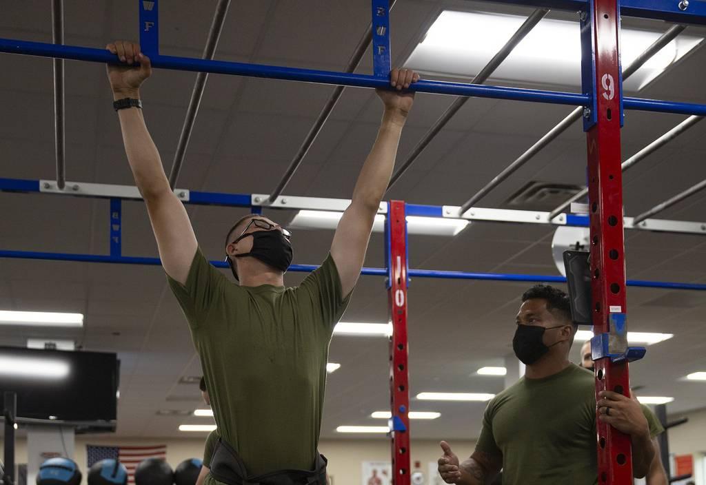 Pvt. Wyatt Hicks, left, a student with School of Infantry East, performs a weighted pullup while Sgt. Brandon Ayers, right, Alpha Company platoon sergeant, monitors his performance at the Human Performance Center on Camp G Smarter not harder: How the Marine Corps wants to improve performance