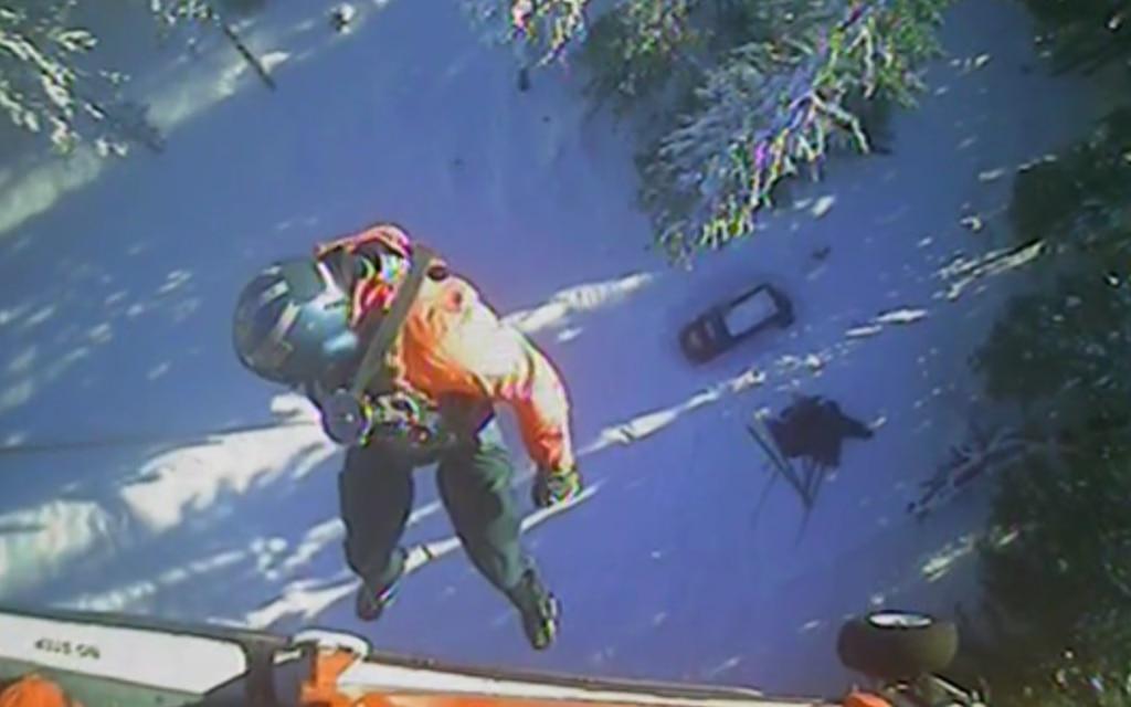 A Coast Guard Sector North Bend MH-65 Dolphin rescue helicopter crew hoists two 19-year-old males reported missing after hiking on Swastika Mountain approximately 32 miles east southeast of Eugene, Oregon, Jan 1., 2022. (C Coast Guard rescues missing hikers who wrote â€˜SOSâ€™ in the snow