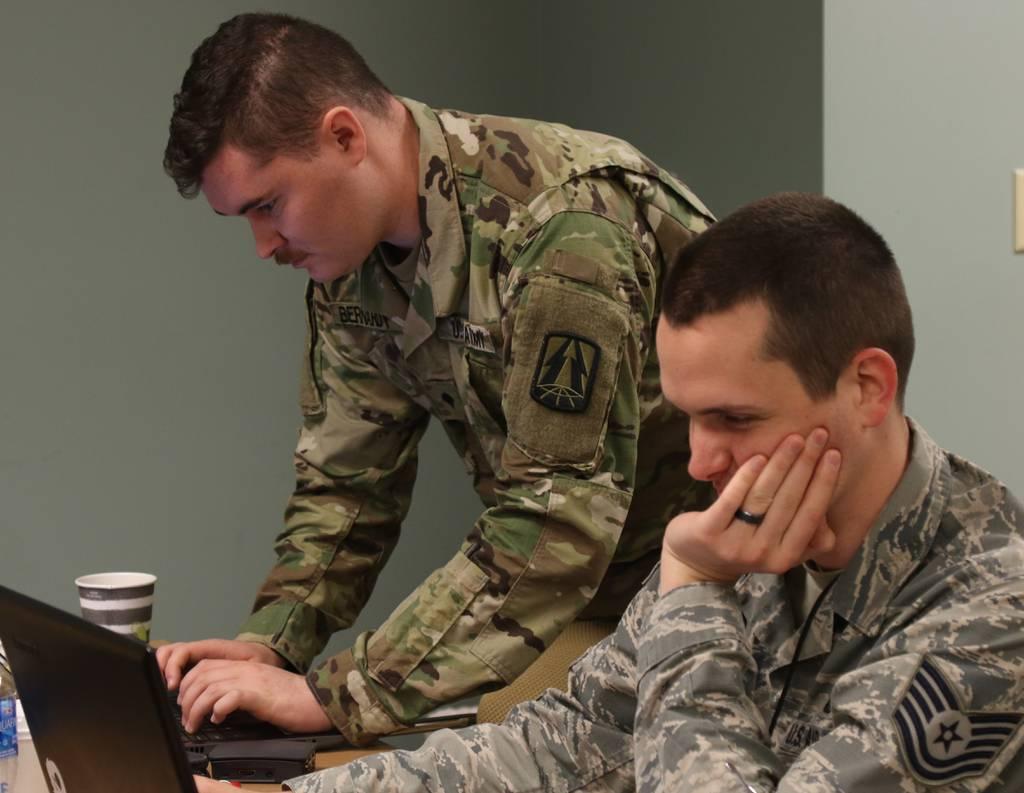 U.S. Army Spc. Cody Bernardy, assigned to the Army Reserve Cyber Operations Group (ARCOG), North Central Cyber Protection Center, 335th Signal Command (Theater), analyzes network data with an Air Force Tech Sgt. during Cyb In change, Army to allow file downloads for Army 365 email on personal devices