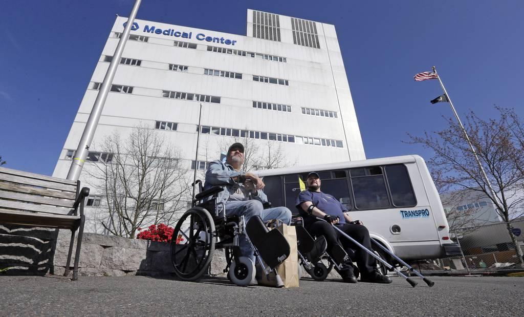 Veterans wait outside the Puget Sound Veterans Affairs Medical Center in Seattle March 30, 2015. (Elaine Thompson/AP) Troops would automatically be enrolled in VA health care under House plan