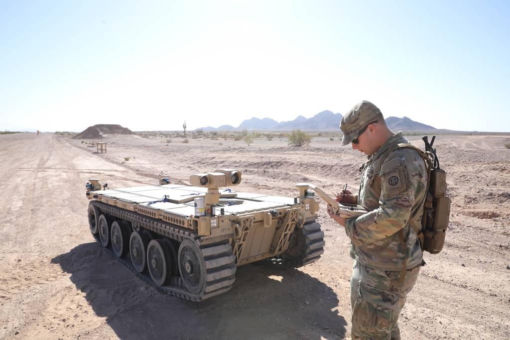 Army Pfc. Daniel Candales, 82nd Airborne Division, uses the tactical robotic controller to control the expeditionary modular autonomous vehicle as a practice exercise in preparation for Project Convergence at Yuma Proving  Army-led hackathon awards cash to autonomous off road vehicle developers