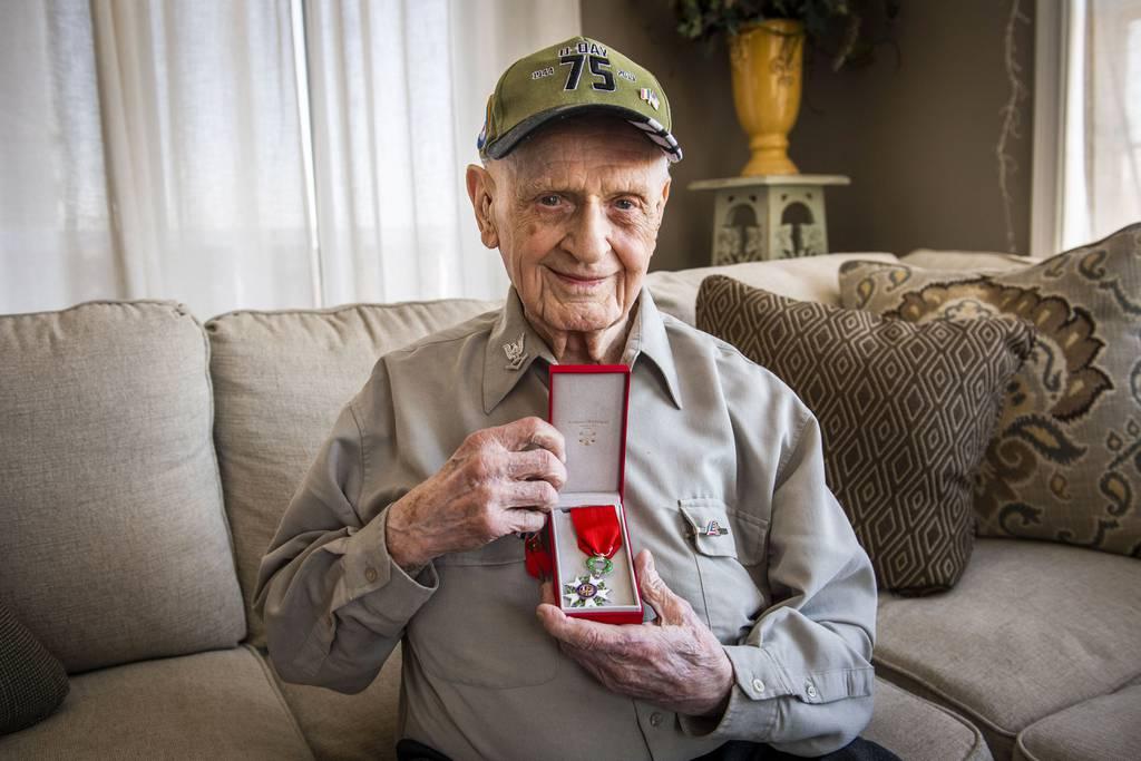 Signalman First Class U.S. Navy veteran Carl Felton holds the French Legion of Honor medal inside of a family home in New Market, Md., on Feb. 15, 2022. (Katina Zentz/The Frederick News-Post via AP) WWII vet honored by France for D-Day contributions
